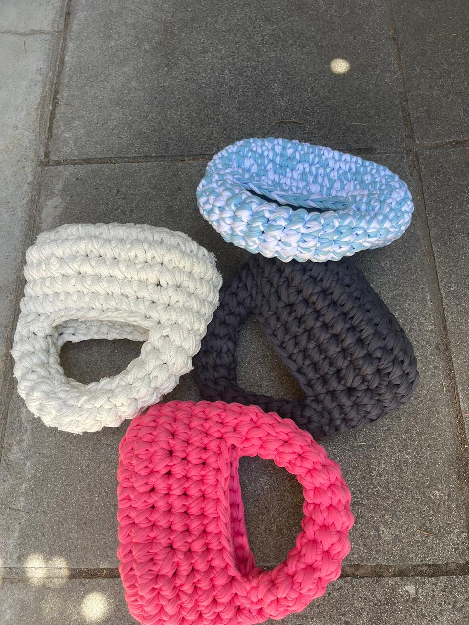 Four crochet handbags photographed flat lay